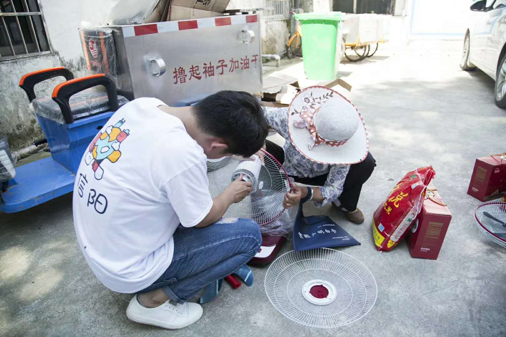 志愿公益活动中团队帮助居民检修生活用品